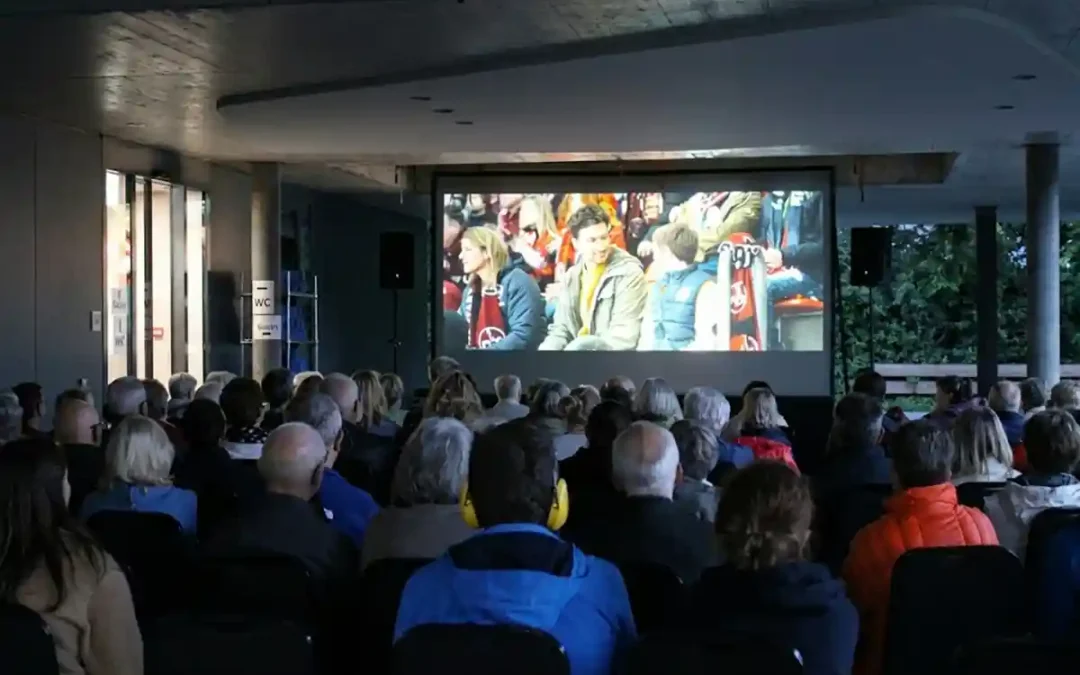 Zuschauer schauen auf Leinwand