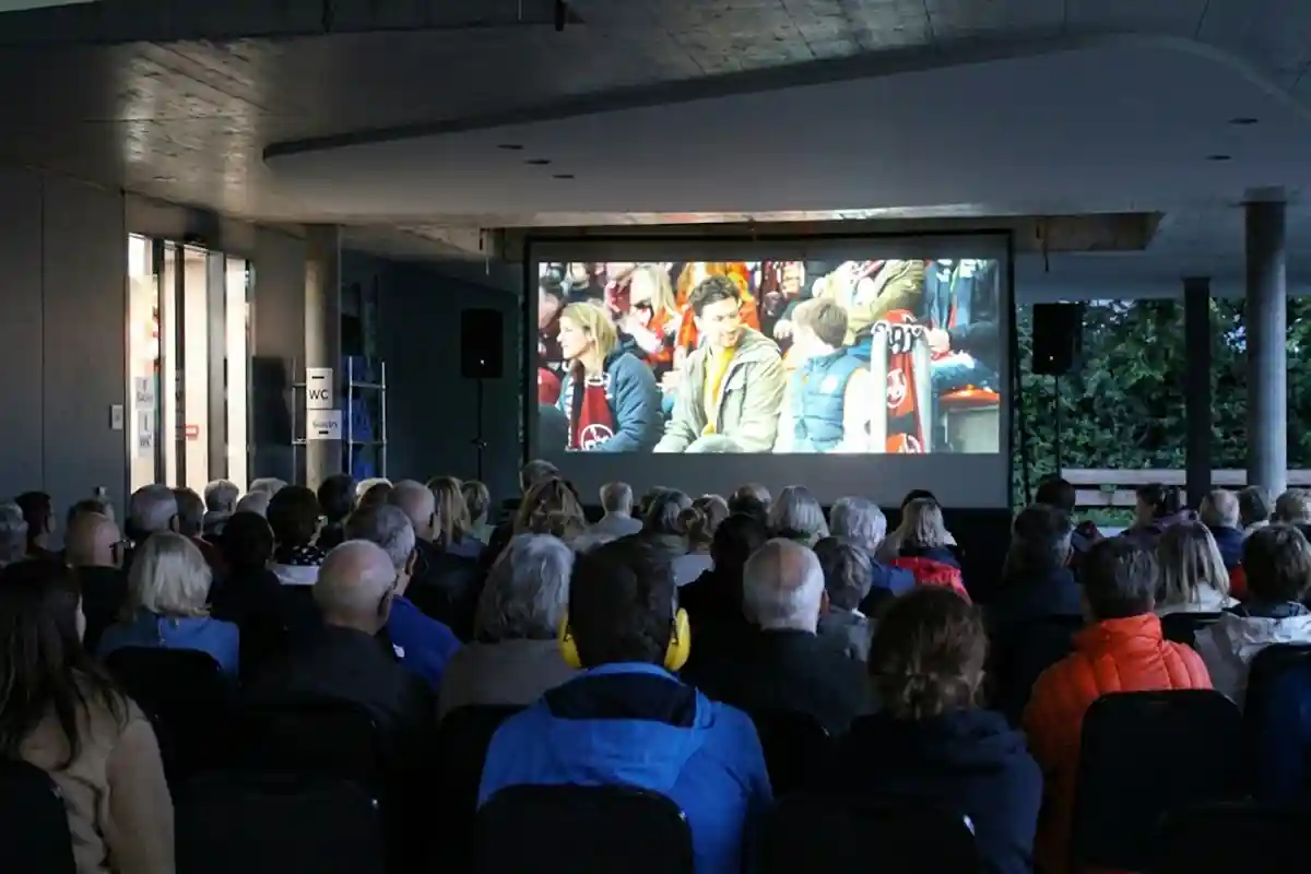 Zuschauer schauen auf Leinwand